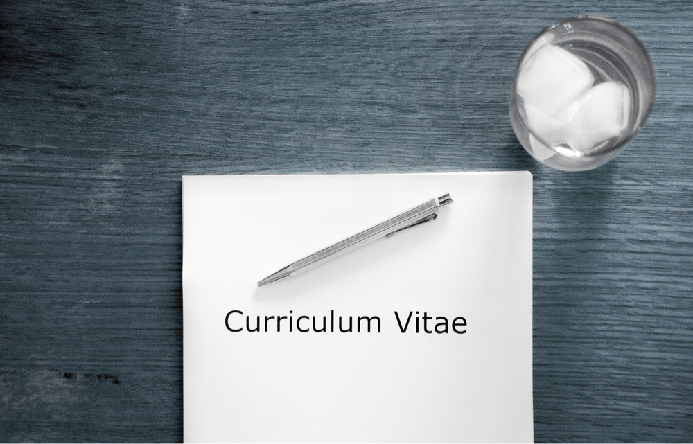 Photo d'un bureau avec un curriculum vitae dans un context d'entrevue